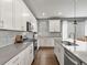 This modern kitchen has stainless steel appliances, light countertops, and bright, white cabinets at 5716 Boston Ct, Denver, CO 80238