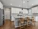 This open kitchen features white cabinets, stainless steel appliances, and hardwood floors at 5716 Boston Ct, Denver, CO 80238