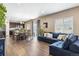 Open floor plan with dark hardwood floors, oversized sofa, dining table, and kitchen at 12835 Randles Ave, Parker, CO 80134