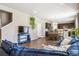 Open concept living room with hardwood floors, oversized sofa, and view of the kitchen at 12835 Randles Ave, Parker, CO 80134