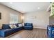 Living room area with large sectional sofa, light colored walls and hardwood floors at 12835 Randles Ave, Parker, CO 80134