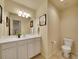 Charming bathroom with a white vanity, framed mirror, neutral walls and flooring, plus a toilet at 485 Sapphire Dr, Castle Rock, CO 80108