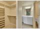 Bright bathroom with white vanity, shelving, and a mirror plus a walk-in closet with built-in shelves at 485 Sapphire Dr, Castle Rock, CO 80108