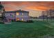 The exterior of a home with a stone facade, a manicured backyard, and a view of the white perimeter fence at 485 Sapphire Dr, Castle Rock, CO 80108