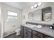 Well-lit bathroom features a granite vanity, framed mirror, and a window for natural light at 3760 Hoyt St, Wheat Ridge, CO 80033