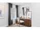 A small home office with a dark wooden desk, neutral chair, mirror and framed art above at 6641 E 148Th Dr # 4, Thornton, CO 80602