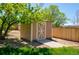 Wooden storage shed with a concrete path, set in a backyard surrounded by trees and greenery at 9688 Chesapeake St, Highlands Ranch, CO 80126