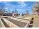 Large backyard with raised garden beds, storage sheds and a partial view of the house at 4040 S Inca St, Englewood, CO 80110
