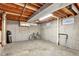 Unfinished basement featuring exposed wood ceiling, concrete walls, and bicycle at 4040 S Inca St, Englewood, CO 80110