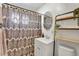 Well-lit bathroom with a patterned shower curtain, modern sink, and decorative shelving at 4040 S Inca St, Englewood, CO 80110