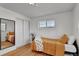 Cozy bedroom with hardwood floors, a full-length mirror, and a closet with sliding doors at 4040 S Inca St, Englewood, CO 80110