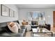 Cozy living room featuring a stylish black sectional sofa with decorative pillows and warm natural light at 4040 S Inca St, Englewood, CO 80110