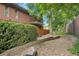 Lush backyard with stone pathway, manicured shrubbery, and brick home exterior at 3470 S Race St, Englewood, CO 80113