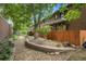 Landscaped backyard featuring stone pathway, wood fence and mature trees at 3470 S Race St, Englewood, CO 80113