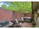 Private brick patio with a hot tub, grill, and outdoor seating under green foliage at 3470 S Race St, Englewood, CO 80113