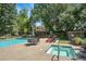 Community pool area featuring lounge chairs, tables, and a jacuzzi surrounded by lush greenery at 3470 S Race St, Englewood, CO 80113