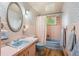 Charming bathroom with blue fixtures, pink tile and wallpaper, and a window for natural light at 3225 S Race St, Englewood, CO 80113