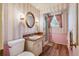 Bathroom with pink striped wallpaper, wood vanity, and a walk-in shower at 3225 S Race St, Englewood, CO 80113