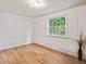 Bright bedroom with hardwood floors, white walls with trim, and a large window to the backyard at 3225 S Race St, Englewood, CO 80113