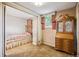 Cozy bedroom featuring a bed, window with curtains, vintage furniture and light brown carpet at 3225 S Race St, Englewood, CO 80113