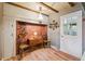 A breakfast nook featuring a brick accent wall with a vintage lamp and views to an adjacent hall and kitchen at 3225 S Race St, Englewood, CO 80113