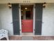 Close up of a red dutch door with decorative sconces and a view into the home's foyer at 3225 S Race St, Englewood, CO 80113