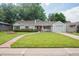 Charming single-story home featuring a well-manicured lawn, pathway and a delightful front garden at 3225 S Race St, Englewood, CO 80113