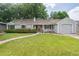 Inviting single-story home featuring a red front door, well-kept lawn, and an attached one car garage at 3225 S Race St, Englewood, CO 80113