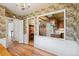 Hallway featuring hardwood floors and vintage floral wallpaper connecting to the kitchen and offering closet space at 3225 S Race St, Englewood, CO 80113