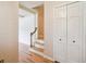 Hallway with wood floors, closet, and view of stairs with a wooden railing at 3225 S Race St, Englewood, CO 80113