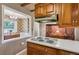 Kitchen with wooden cabinets and countertops featuring a vintage electric stovetop and view into a vintage dining room at 3225 S Race St, Englewood, CO 80113