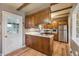 A cozy kitchen with wood cabinets, laminate countertops and stainless steel appliances featuring a door to the exterior at 3225 S Race St, Englewood, CO 80113
