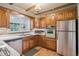 The kitchen has wood cabinetry, laminate countertops, stainless appliances, wooden beams and a large window at 3225 S Race St, Englewood, CO 80113