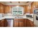 Kitchen featuring wood cabinets, laminate countertops, stainless steel appliances, and a window for natural light at 3225 S Race St, Englewood, CO 80113