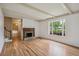 Bright living room with hardwood floors, a fireplace and large windows offering a view of the neighborhood at 3225 S Race St, Englewood, CO 80113