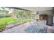 Covered patio with stone floor, outdoor seating, and backyard views with mature trees at 3225 S Race St, Englewood, CO 80113
