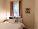 Bright bedroom featuring a cozy bed with decorative pillows and a window with neutral curtains at 2614 Curtis St, Denver, CO 80205