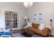 Bright living room with a tan leather couch, french doors, and neutral decor at 2614 Curtis St, Denver, CO 80205