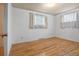 Cozy bedroom featuring gleaming hardwood floors and ample natural light from the large windows at 1373 S Cape Way, Lakewood, CO 80232