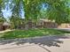 A quaint brick home with a well-manicured lawn and established trees, creating a welcoming curb appeal at 1373 S Cape Way, Lakewood, CO 80232