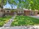 Charming brick home featuring a well-maintained front yard and mature trees that provide ample shade at 1373 S Cape Way, Lakewood, CO 80232