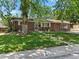 Charming brick home featuring a well-maintained front yard and mature trees that provide ample shade at 1373 S Cape Way, Lakewood, CO 80232