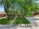 Charming brick home featuring a well-maintained front yard and mature trees that provide ample shade at 1373 S Cape Way, Lakewood, CO 80232