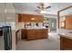 Open kitchen with wood cabinets, neutral countertops, and access to living area at 1373 S Cape Way, Lakewood, CO 80232