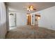 Bright living room featuring neutral carpet, a ceiling fan and easy access to the kitchen and front door at 1373 S Cape Way, Lakewood, CO 80232