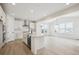 Modern kitchen with white cabinets, island, and stainless steel appliances at 692 Apex Rise St, Erie, CO 80516