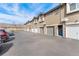 Exterior view showcasing condo garages and parking spaces against a blue sky at 3205 S Walden Ct # B, Aurora, CO 80013