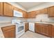 Well-maintained kitchen featuring light wood cabinets and white appliances at 3205 S Walden Ct # B, Aurora, CO 80013
