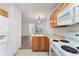 Efficient kitchen with white appliances and wood cabinets open to the adjacent living room at 3205 S Walden Ct # B, Aurora, CO 80013