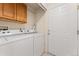 Bright laundry room with cabinetry and a side entrance door at 3205 S Walden Ct # B, Aurora, CO 80013